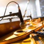 Photo of a single mic above a piano.