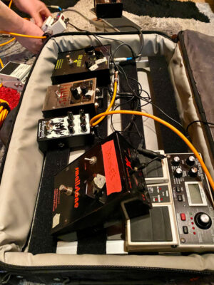 A picture of a guitar pedal board with several guitar pedals. 